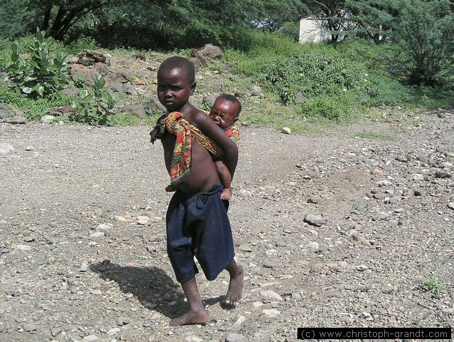 child carrying child, near Lake Baringo